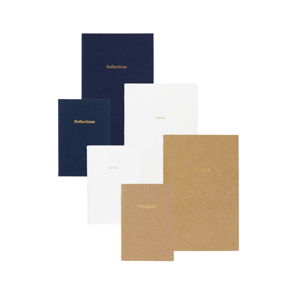 A collection of notebooks in various sizes and colors, including navy, white, and kraft paper, labeled 'Reflections,' 'Ideas,' and 'Thoughts.'