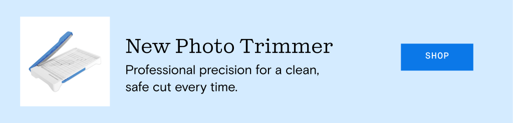 An image of a new photo trimmer with a blue handle, placed on a light blue background. The text next to it reads 'New Photo Trimmer' and describes it as providing professional precision for a clean, safe cut every time.